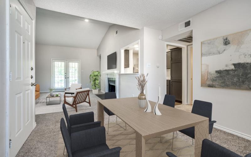 a dining room with a table and chairs leading into a living room