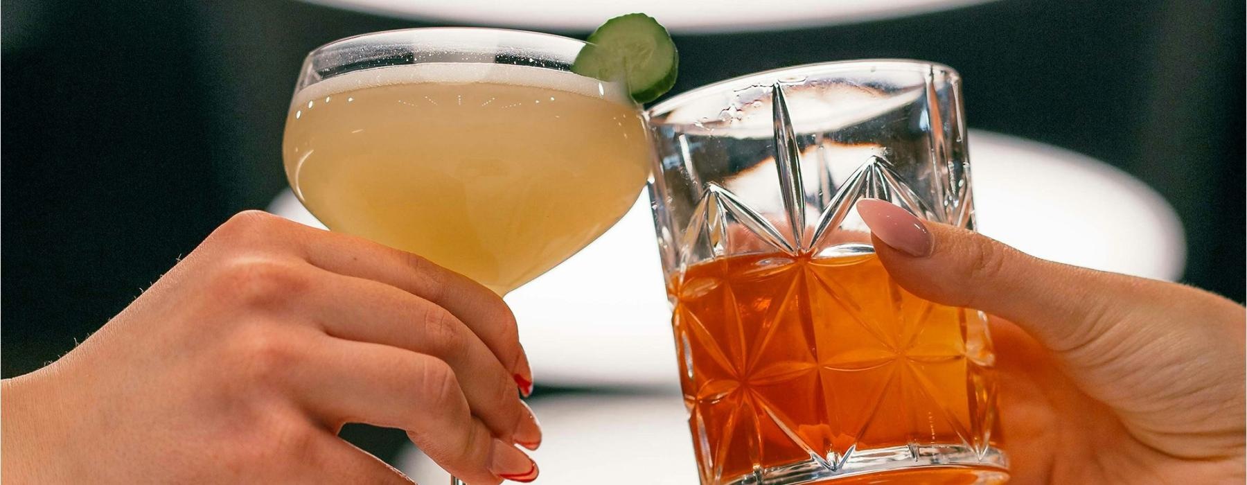 hands holding glasses with cocktails