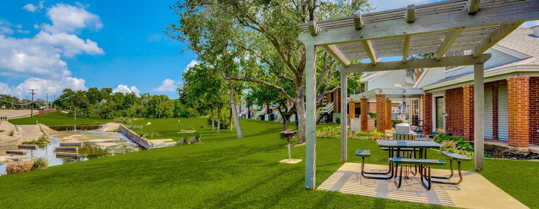 a building with a picnic table and a tree in the front